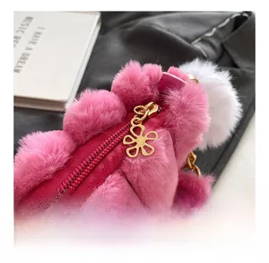 Close-up of pink faux fur bag featuring a gold flower zipper and smooth metallic chain
