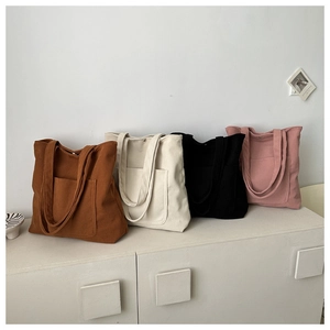 Detailed display of corduroy tote bags in multiple colors with large front pockets