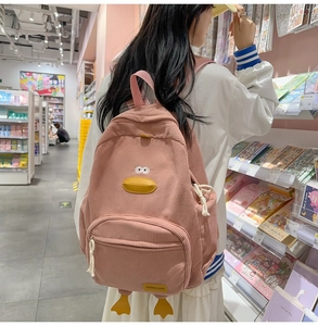 Close-up of pink corduroy backpack featuring unique cartoon duck 3D design details