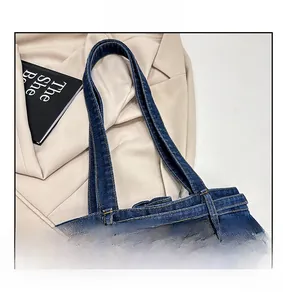 Close-up of wide denim shoulder strap with durable double yellow stitching details