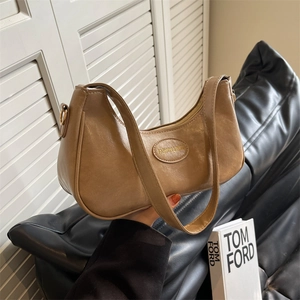 Minimalist light brown hobo bag with pleated leather texture and wide shoulder strap