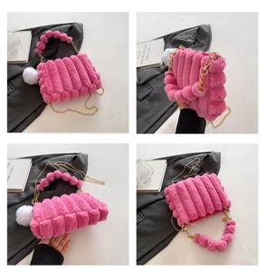 Detail view of pink faux fur handbag featuring gold chain and decorative plush pom-poms