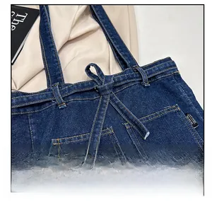 Detail showing deep blue denim tote bag with drawstring closure and contrast stitching