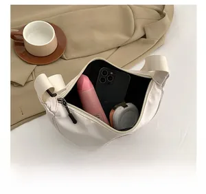 Internal view of a white crescent crossbody bag showing ample storage for daily essentials