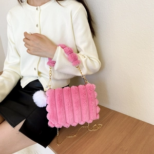 Detailed texture of pink faux fur handbag with vertical stripes and golden chain strap