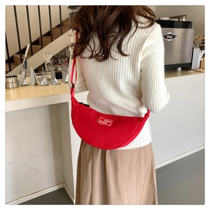 Detail view of red crescent fanny pack showing the YUN QING logo and canvas texture