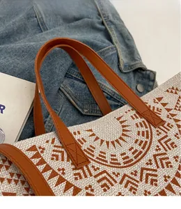 Detail of ethnic canvas tote bag showing woven texture, geometric patterns and leather straps