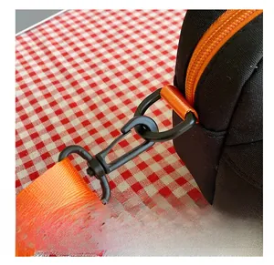 Detail view of durable black canvas bag with orange zipper and secure swivel hook