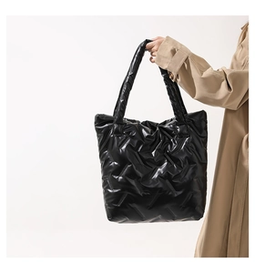 Détail du grand sac cabas noir brillant matelassé avec texture bouffante élégante