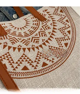 Close-up of ethnic geometric pattern on linen tote bag with brown leather straps