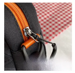Close-up of bright orange zipper and black fabric texture on minimalist canvas bag