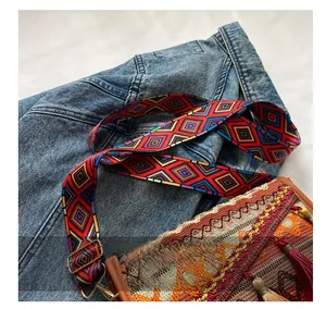 Close-up of colorful ethnic woven wide shoulder strap with red tassels on the bag