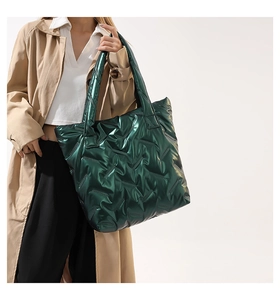 Détail du grand sac cabas matelassé vert métallisé porté avec un trench beige chic