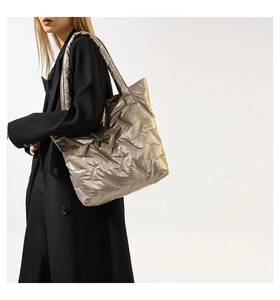 Détail du sac cabas matelassé argent champagne porté à l'épaule pour le quotidien