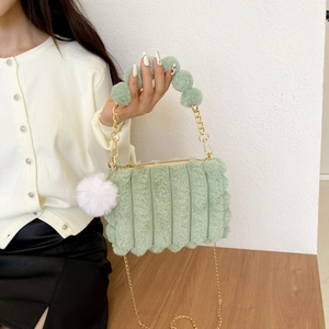 Detail of light green plush handbag with vertical pleats and soft faux fur texture
