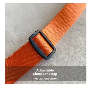 Detail of adjustable bright orange nylon shoulder strap with durable black buckle