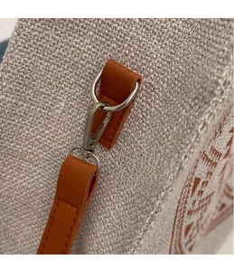 Detail of silver metal hook and brown leather strap on ethnic canvas tote bag