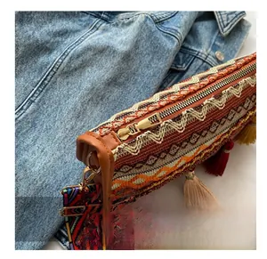 Detailed macro of smooth gold metal zipper and ethnic tapestry texture on boho bag