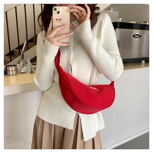 Detail of red crescent crossbody bag featuring durable nylon fabric and adjustable strap