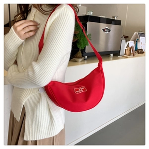 Detail of red canvas crescent bag with YUN QING embroidery and adjustable strap