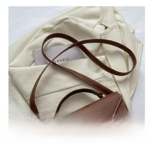 Détails du sac à main en cuir bicolore avec fermoir métallique doré et bandoulière