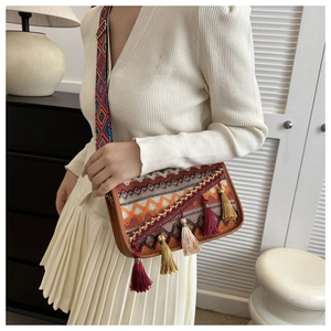 Close-up of bohemian crossbody bag with colorful jacquard pattern and hanging tassels