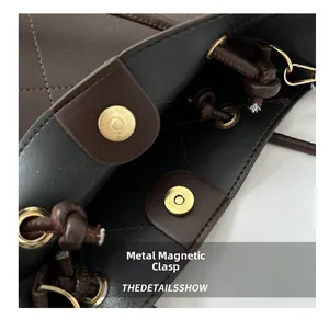 Gros plan de la boucle magnétique dorée sur le sac en cuir matelassé marron