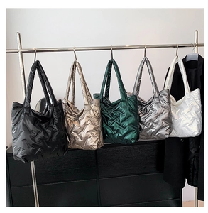 Sacs cabas rembourrés en tissu duvet en plusieurs couleurs métallisées sur un présentoir