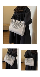 Detail of linen tote bag featuring geometric mandala prints and black leather handles