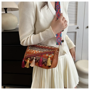 Detail of bohemian shoulder bag featuring colorful tassels and woven ethnic patterns