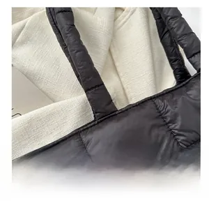 Detailed macro view of black quilted puffer tote bag with premium stitching and soft nylon texture
