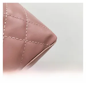 Detailed close-up of pink quilted leather bag with classic diamond stitch and pebble texture