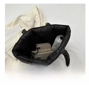 Detail view showing large interior capacity of the black quilted puffer tote bag