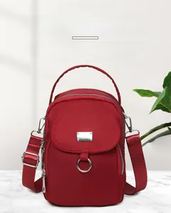 Detailed view of red waterproof nylon mini phone bag with multiple zipper compartments
