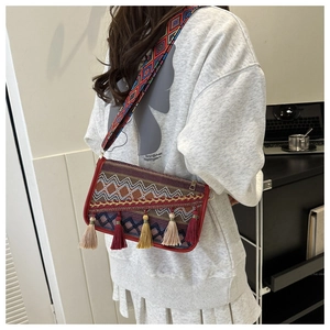 Detailed view of bohemian woven crossbody bag with colorful patterns and tassels