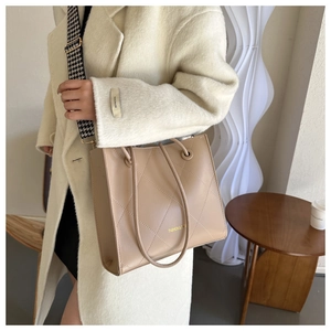 Détail du sac cabas matelassé beige avec une large bandoulière chic à motif pied-de-poule