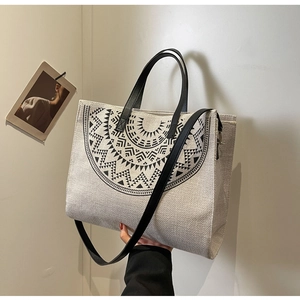 Detail view of ethnic canvas tote bag with geometric print and black leather handles
