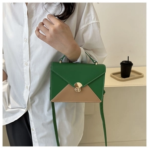Vue détaillée du sac enveloppe contrasté avec fermoir rotatif doré et fines coutures blanches