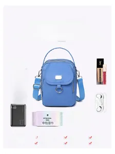 Blue oxford fabric mini crossbody bag showing storage capacity for phone and makeup