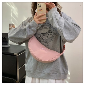 Pink nylon crescent crossbody bag featuring adjustable strap and branded logo detail