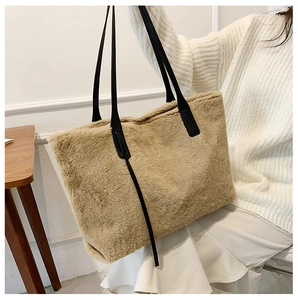 Modische khakifarbene Kunstfell-Tote-Bag mit schwarzen Riemen in gemütlicher Umgebung