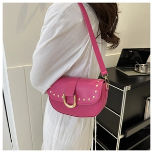 Détail du sac bandoulière rose rouge avec clous dorés et boucle en fer à cheval