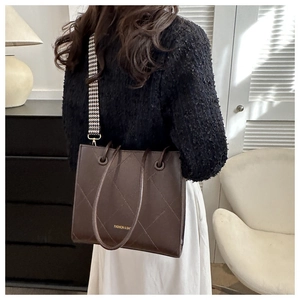 Détail du sac cabas matelassé marron foncé avec bandoulière pied-de-poule et texte mode