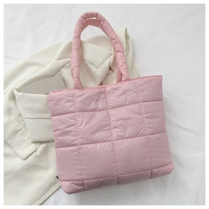 Close-up of pink quilted tote bag showing square stitching and soft padded texture