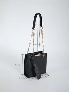 Detail shot of black quilted bag with gold chain strap and textured diamond pattern