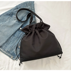 Close-up of black drawstring bucket bag with durable fabric and contrast bottom panel