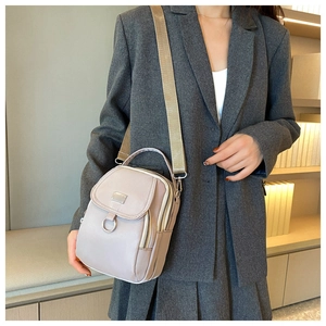 Detail of lavender nylon mini shoulder bag with adjustable strap on a female model