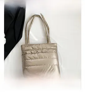 Close-up of champagne quilted puffer tote bag with metallic fabric and stitch detail