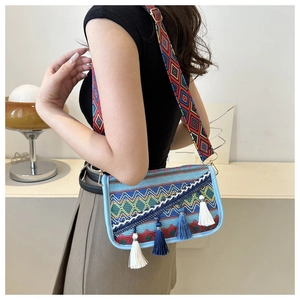 Bohemian woven crossbody bag featuring colorful geometric patterns and long white fringes
