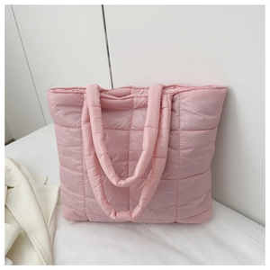 Close-up of light pink quilted tote bag showing square stitching and soft padded texture